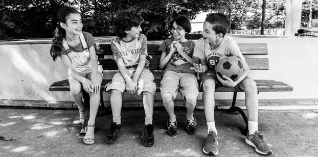 Quatre enfants sur un banc, photographie de l'exposition
